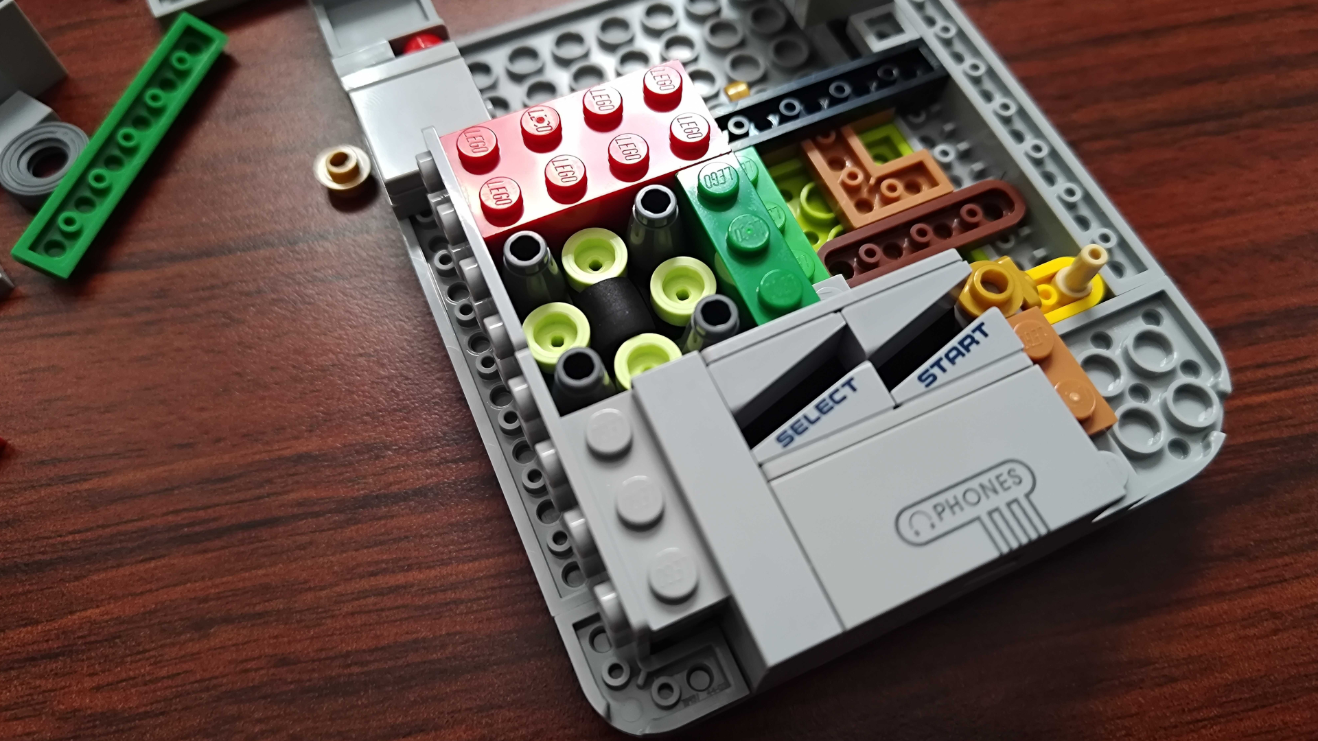 Lego Game Boy partially assembled on a wooden surface