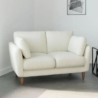 A white boucle sofa with matching cushions
