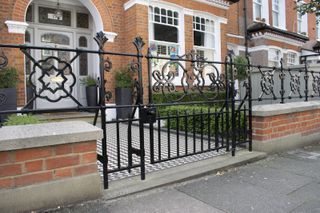 traditional front garden with Victorian pathway tiles and ornate railings