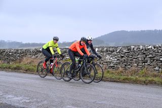 A group of three male riders in winter kit on a cold ride