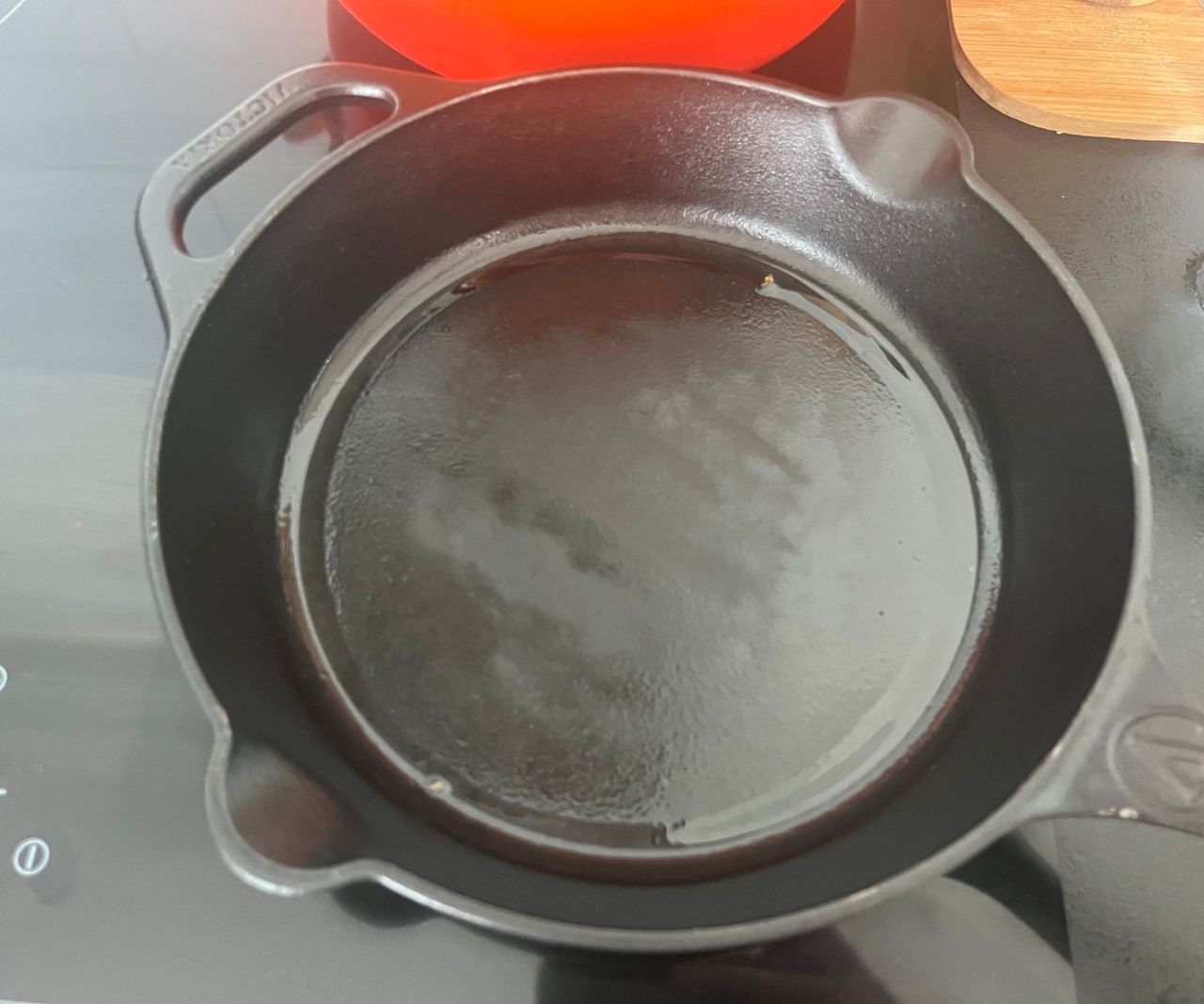 An oiled black cast iron pan on a black stove