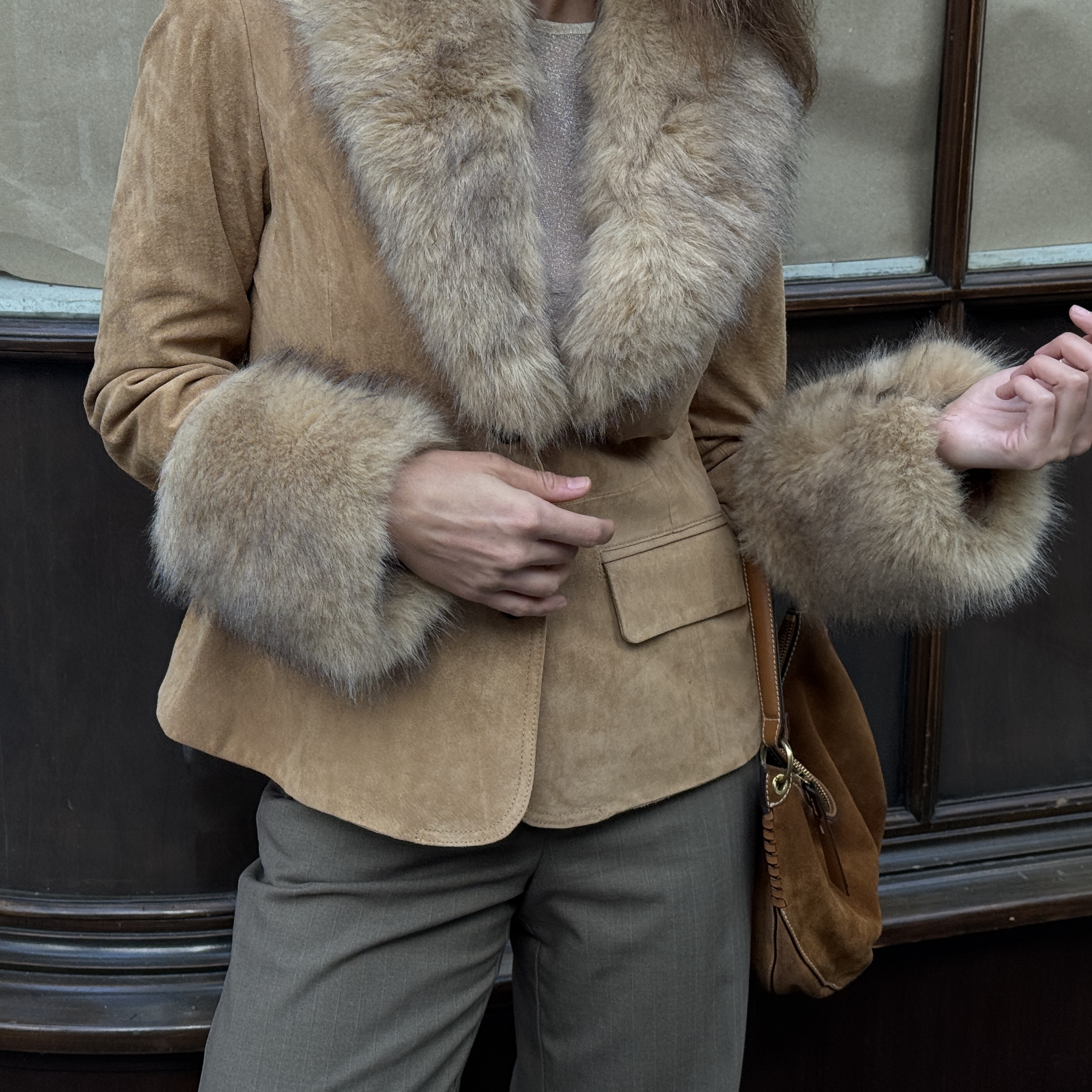 Kathryn Zahorak models a fur trim jacket, green pants, and suede bag