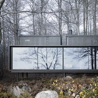 glass cabinet house with green trees and stones