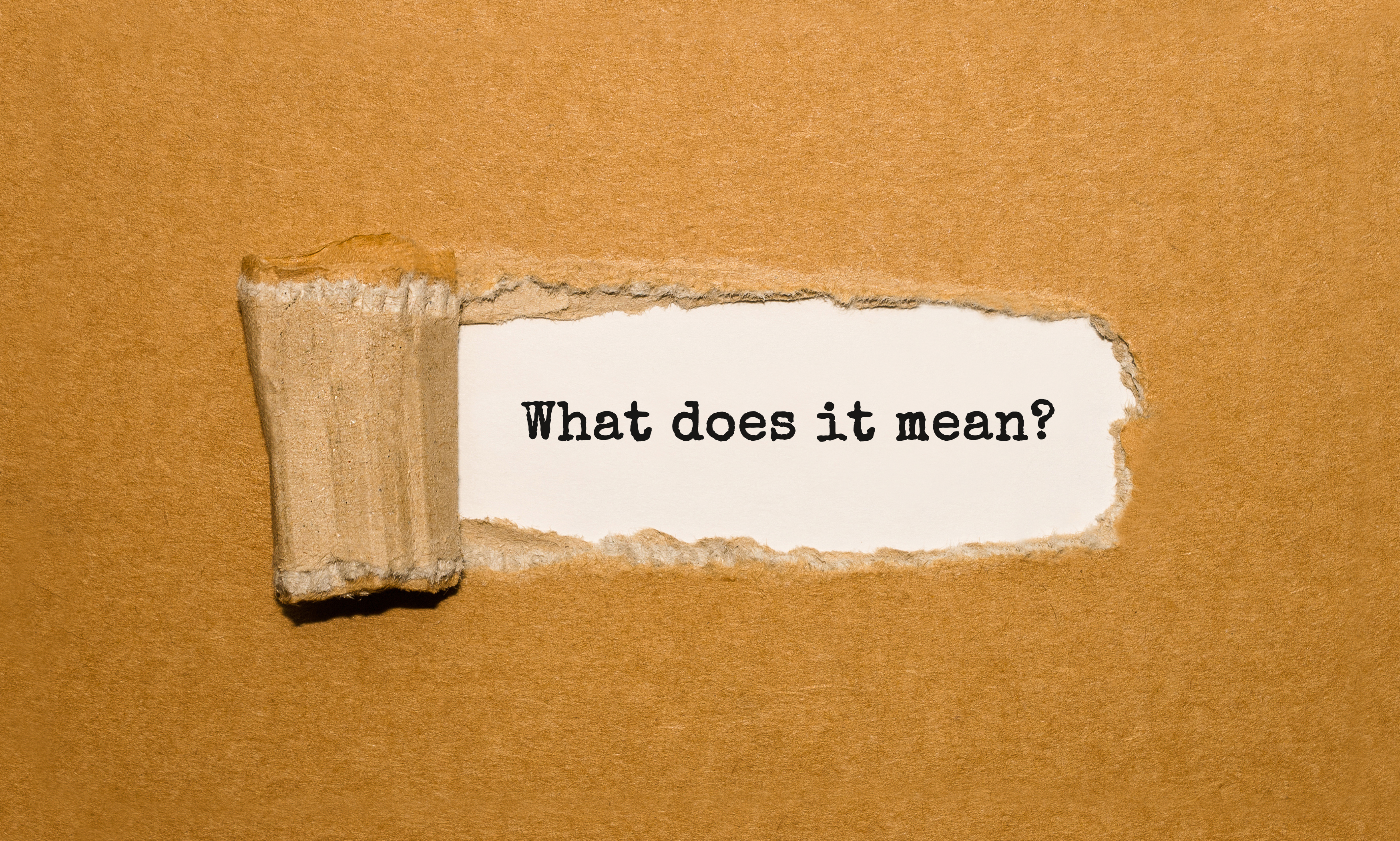 The text What does it mean appearing behind torn brown paper