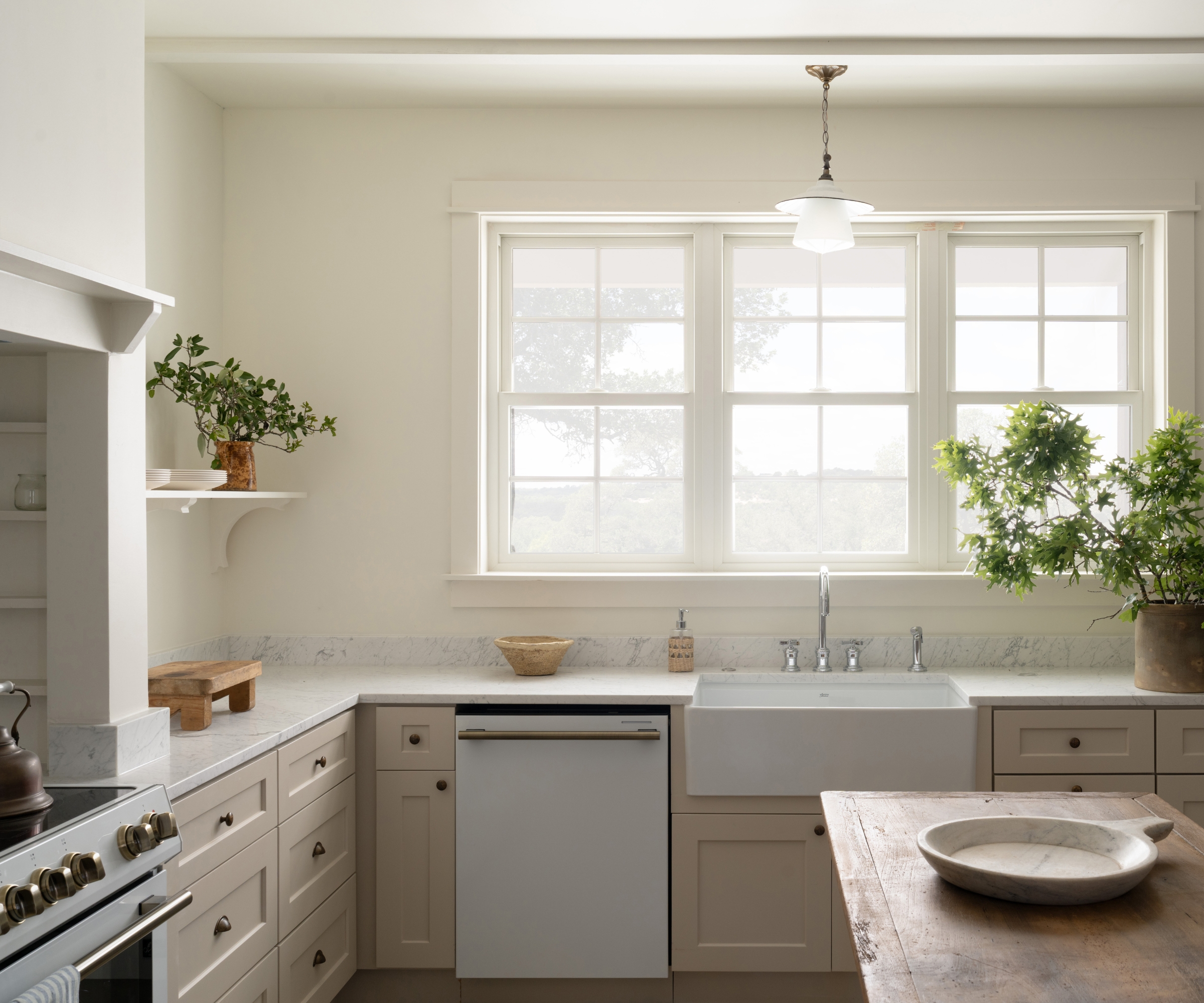 An L-shaped kitchen with cabinets painted in Sherwin-Williams Alabaster
