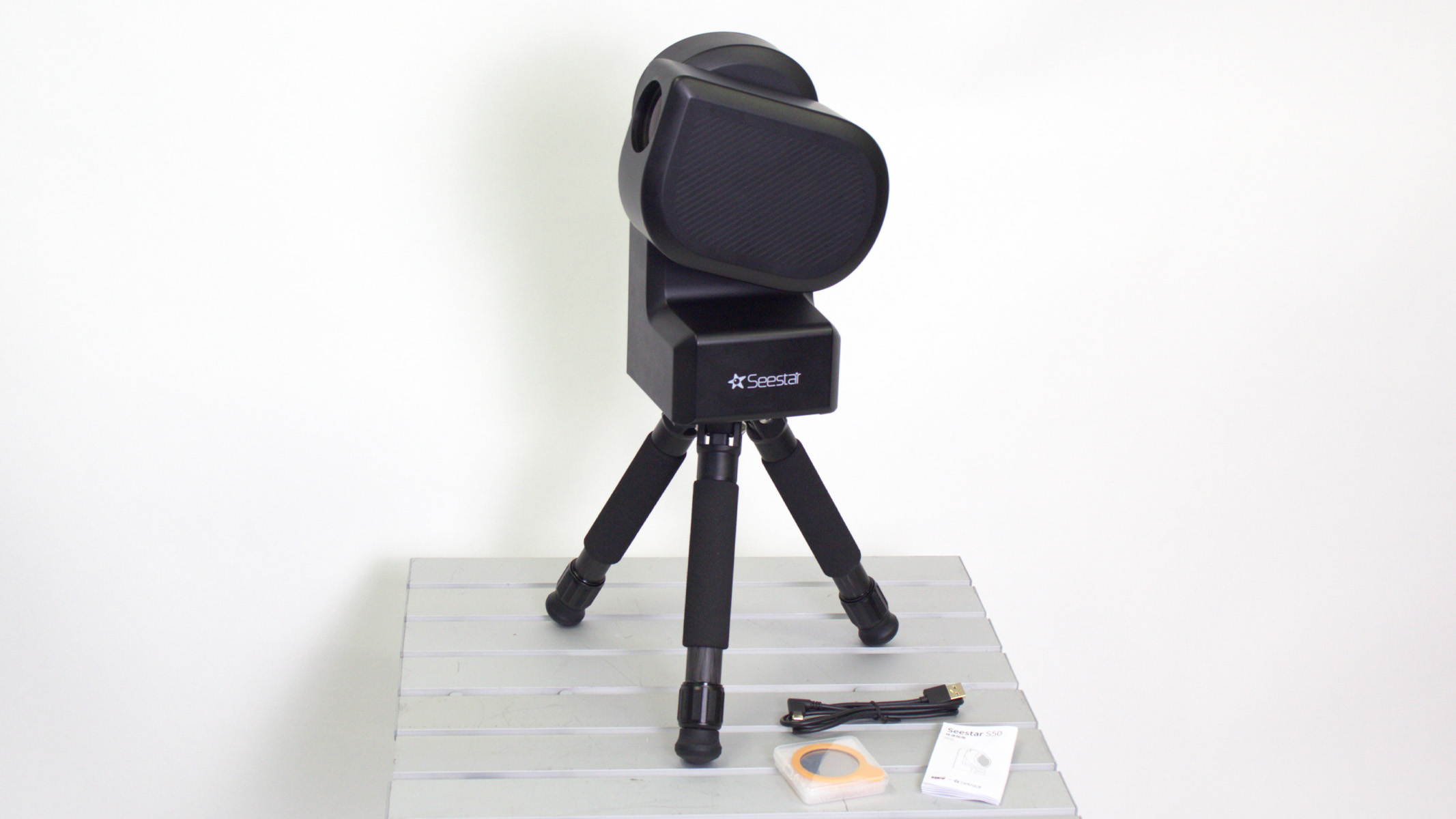 ZWO Seestar S50 on a table against a white wall