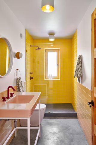 Bathroom with concrete floor and yellow tiled walls