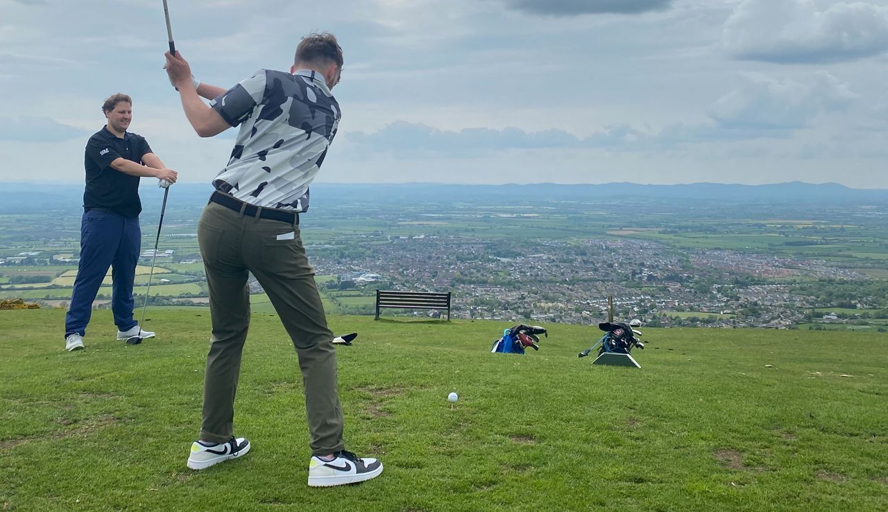 A golfer takes a swing on the tee box