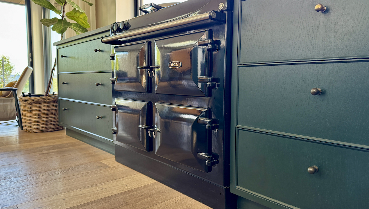 black aga in green kitchen with wood flooring 