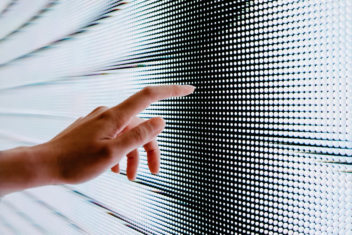 Close up of woman&amp;#039;s hand touching illuminated LED display screen, connecting to the future