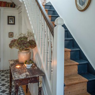 traditional hallway in an Edwardian home with decorative floor tiles and stair runner