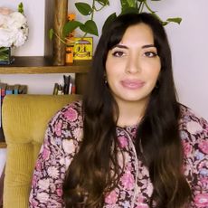 Sarah bahbah sitting in front of her bookshelf in shelf portrait video