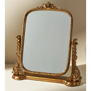 intricately detailed standing vanity mirror in gold