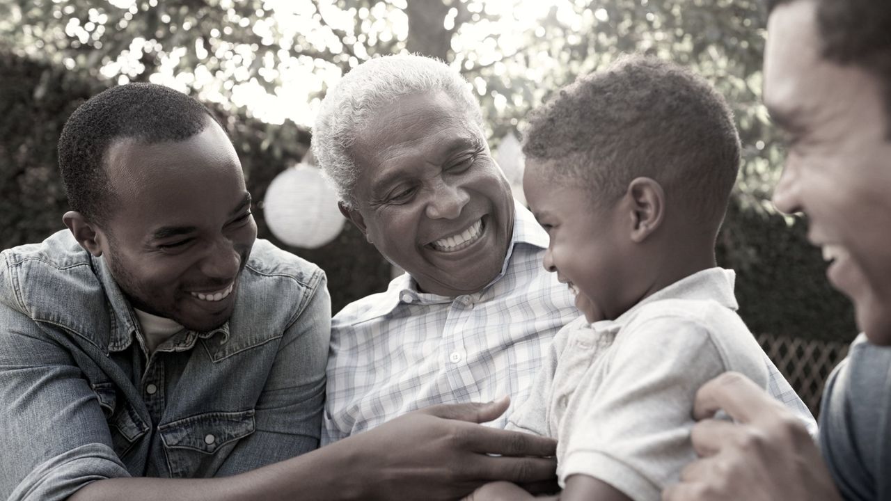 Close up of happy grandfather, sons and grandson in a garden