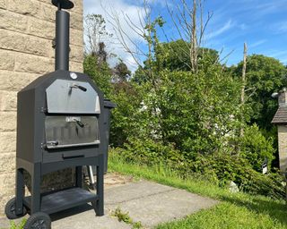 Outsunny Outdoor Garden Pizza Oven Charcoal BBQ outside in the sun