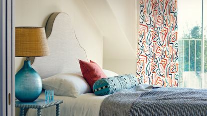 bedroom with large window and patterned curtain