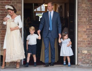 Princess Charlotte and Prince George hold hands with their father, Prince William, Duke of Cambridge, as Prince Louis is carried by his mother, Catherine, Duchess of Cambridge
