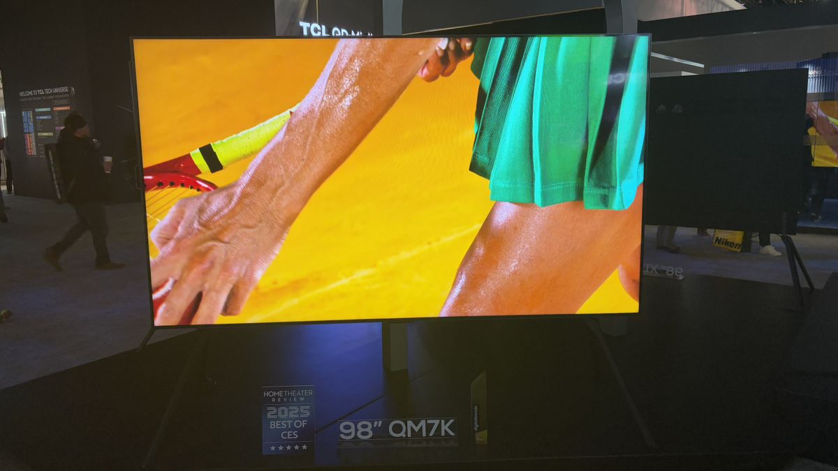 TCL QM7K at the TCL stand with a tennis player and fencers on screen
