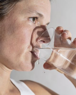 A person drinking a glass of water