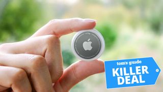 A photo of an Apple AirTag held between the user's fingers, with the "Tom's Guide killer deal" tag overlaid