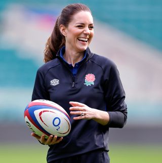 Kate Middleton pictured smiling, while wearing a rugby kit and holding a rugby ball after becoming Patron of the Rugby Football Union at Twickenham Stadium on February 2, 2022 in London, England