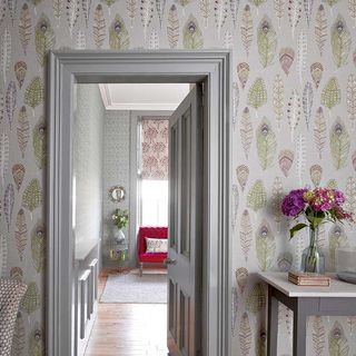 Feather print wallpaper in hallway with grey door and grey frame