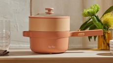 Our Place Perfect Power Pot in terracotta on counter with flowers