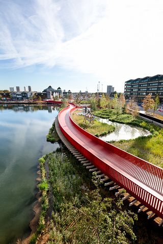 Asif Khan boardwalk at Canada Water bright red bridge across water and natural water wildlife habitat