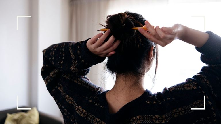Woman with a sore scalp doing her hair with a pencil