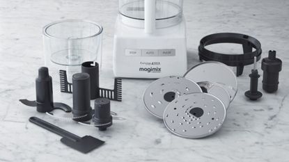 What do the different food processor accessories do: a Magimix food processor attachments on a marble surface