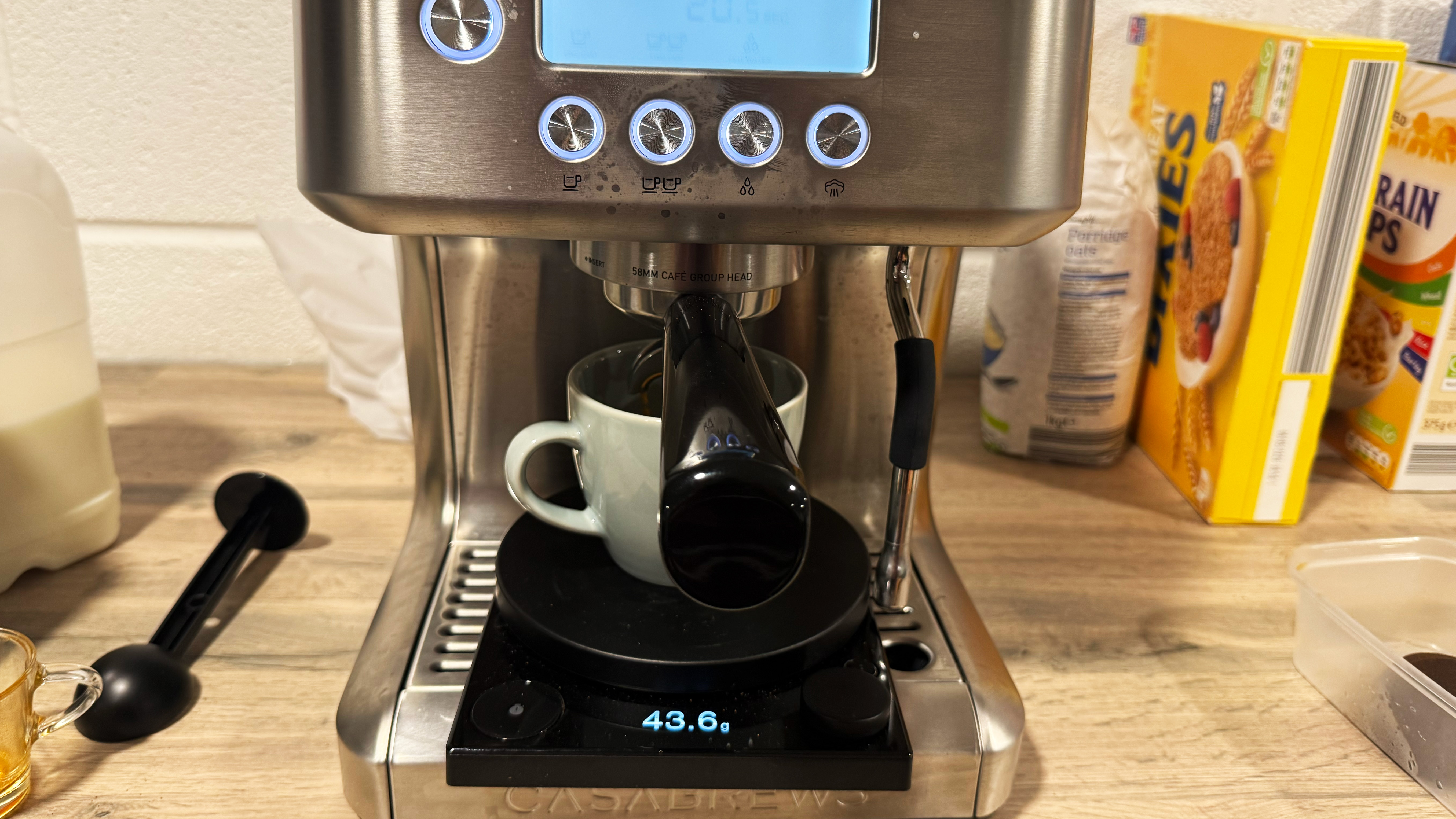the casabrews ultra espresso machine in action with a fellow tally pro coffee scale and mug on the drip tray to measure coffee volume