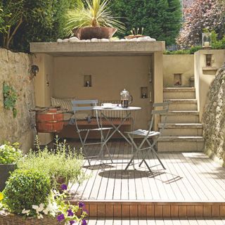 Metal garden furniture seating area on wooden decking in garden terrace