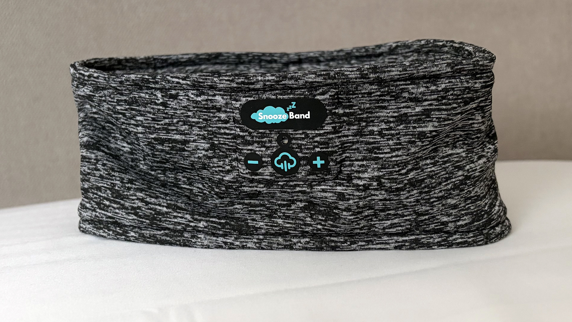 A closeup of the SnoozeBand Original Sleep headband standing upright on a pillow in our reviewer's bedroom