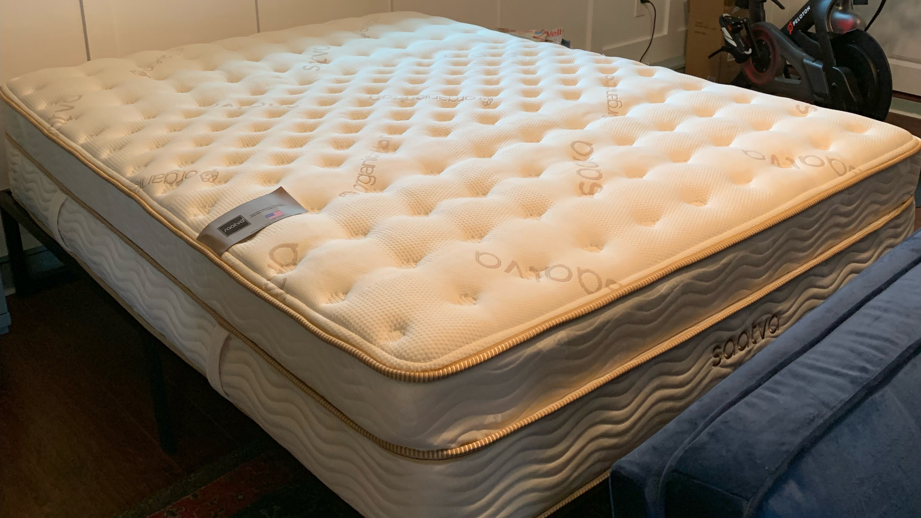 На изображении показан матрас Saatva Classic, установленный на основной каркас кровати.