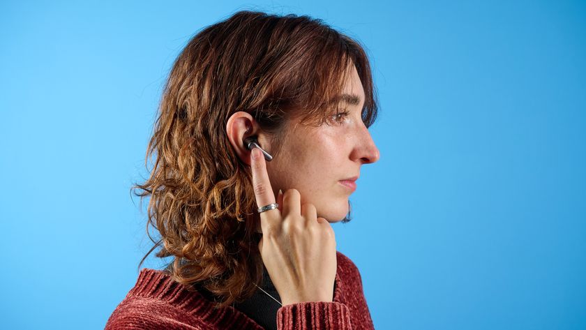 a photo of the author wearing the earfun air pro 4+ earbuds against a blue tom&#039;s guide background
