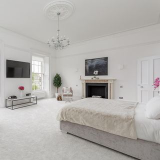 bedroom with white wall bed window and chandelier