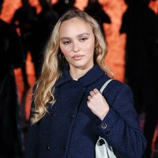 Lily-Rose Depp wearing a navy suit and pattern tights