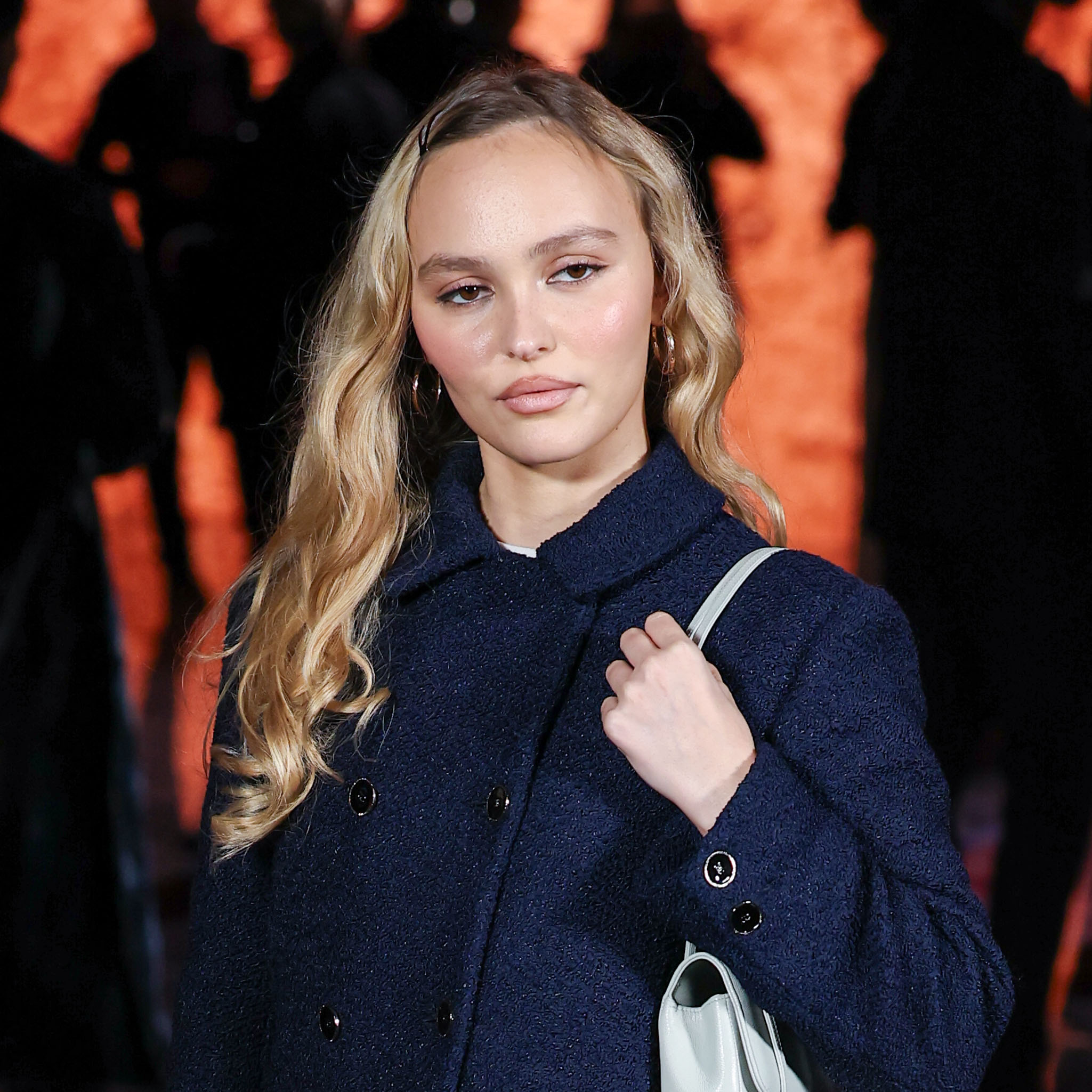 Lily-Rose Depp wearing a navy suit and pattern tights