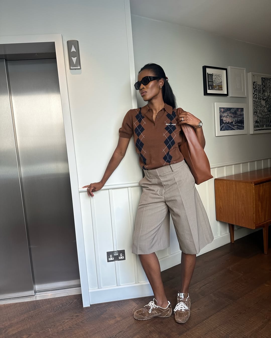 @nlmarilyn wearing brown Miu Miu X New Balance 530 trainers with a Miu Miu polo shirt, Bermuda shorts and leather tote