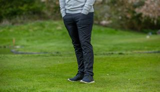 The TravisMathew Open To Close Pant on a green background