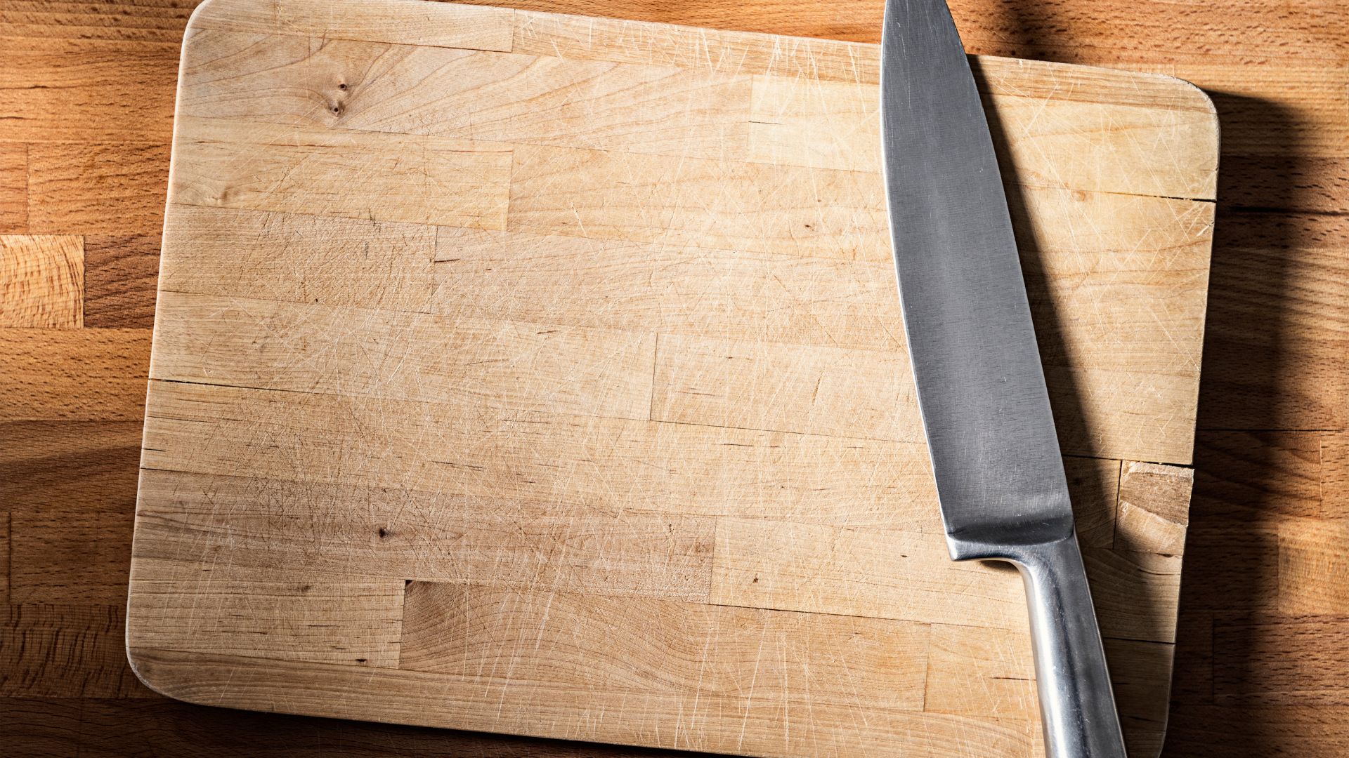 picture of wooden chopping board with knife rested on top