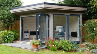 garden office ideas of a pale grey garden office with bi-fold doors