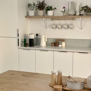 white kitchen cabinetry with floating shelf and accessories