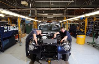 COVENTRY, ENGLAND - SEPTEMBER 11: Steve Wilson (L) and Steve Pearce work on a TX4 London Taxi on the assemby line at the London Taxi Company on September 11, 2013 in Coventry, England. The bu