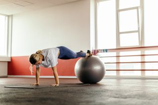 Female cyclist using a swiss ball as part of a bone health boosting routine