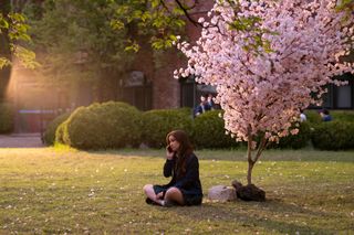 kitty returns to campus in xo kitty season 2 as she sits on the kiss front lawn on the phone