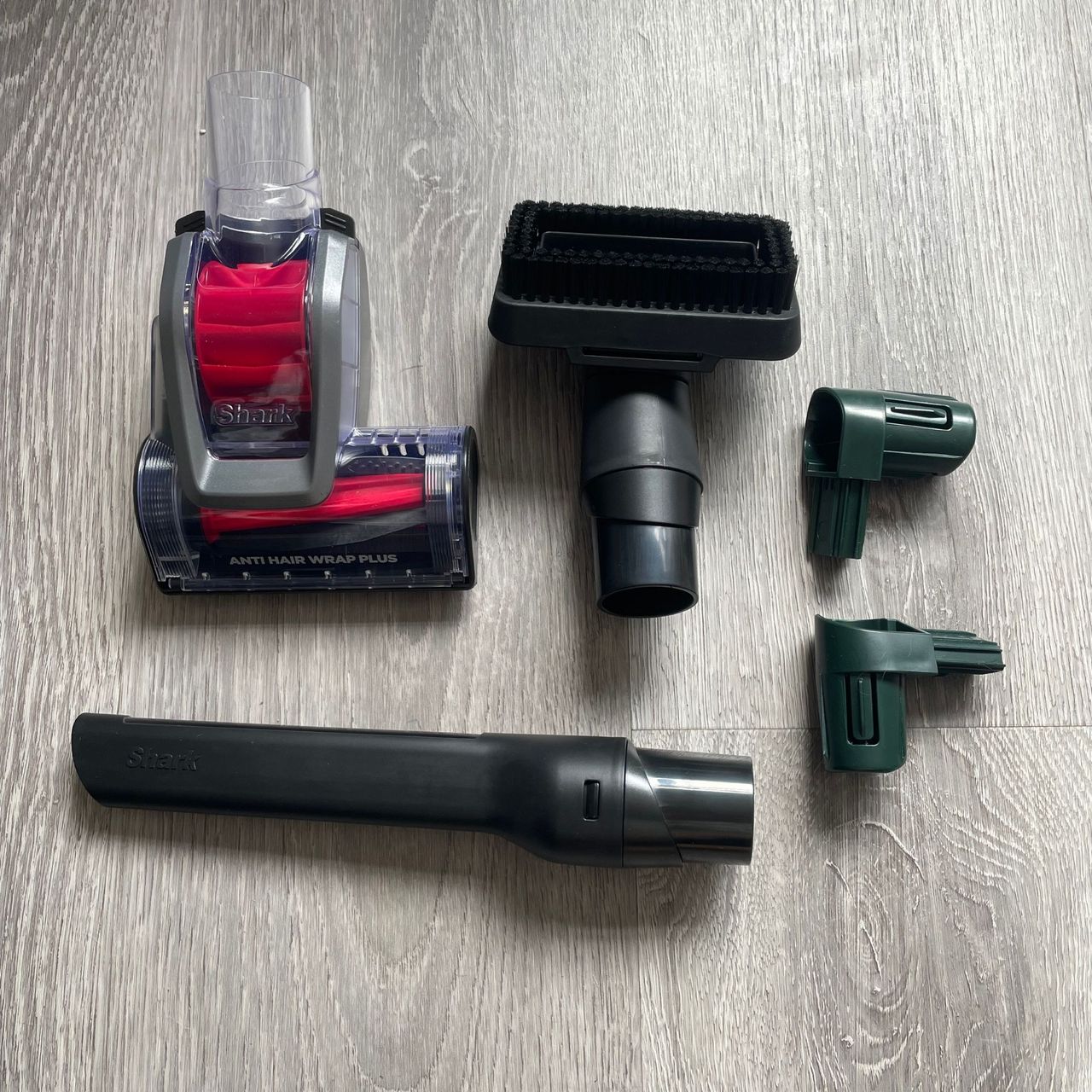 Accessories of a Shark vacuum laying on grey flooring