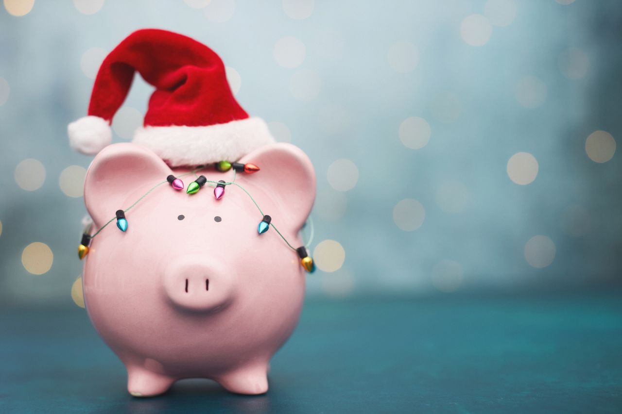 Pink Piggy Bank Wrapped in Holiday Lights and Wearing Santa Hat for Christmas