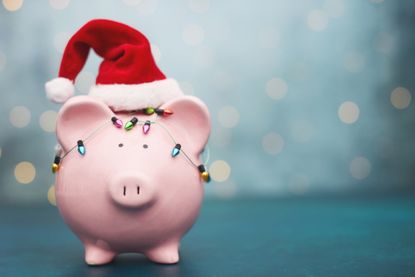 Pink Piggy Bank Wrapped in Holiday Lights and Wearing Santa Hat for Christmas