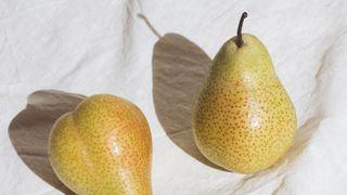 Whole pears sitting on linen tablecloth